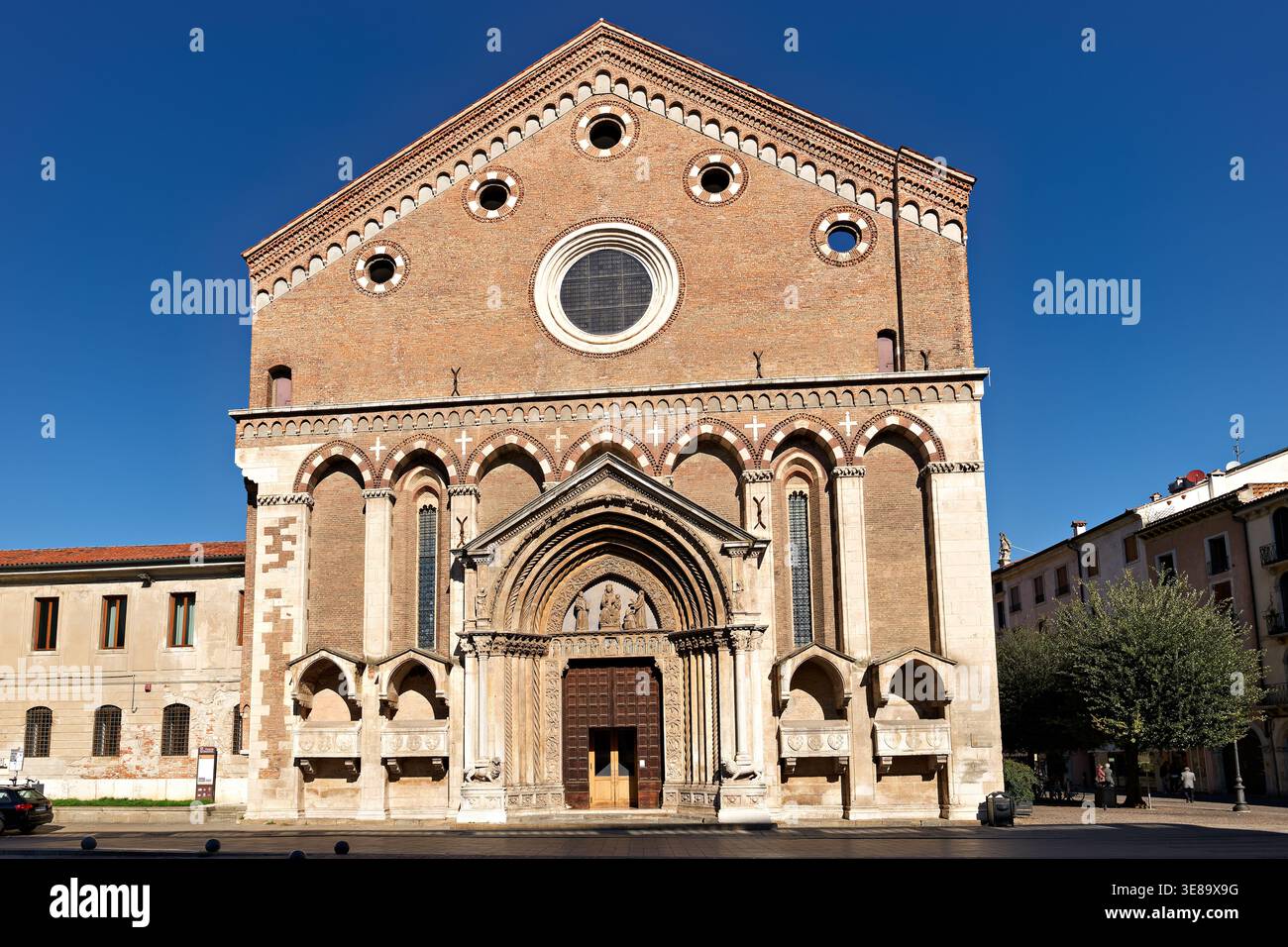 Die Kirche San Lorenzo steht in Vicenza. Das Gebäude verfügt über eine einfache Architektur und einen klaren Himmel dahinter. Die Leute besuchen und bewundern die Struktur. Stockfoto