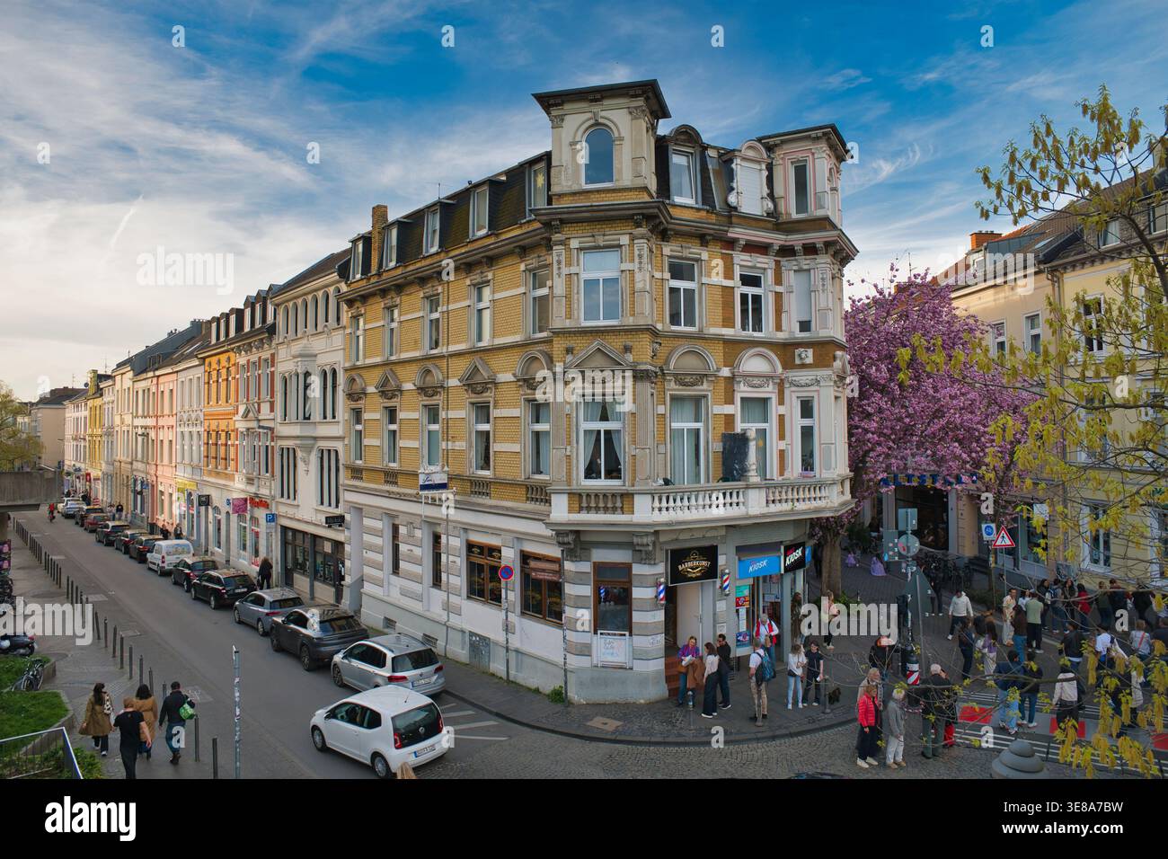 Bonn, Deutschland, 09.04.2026 - historische Wohnhäuser mit Kirschblüten und Fußgängern in Bonn Deutschland charmante europäische Straße im Frühling Stockfoto