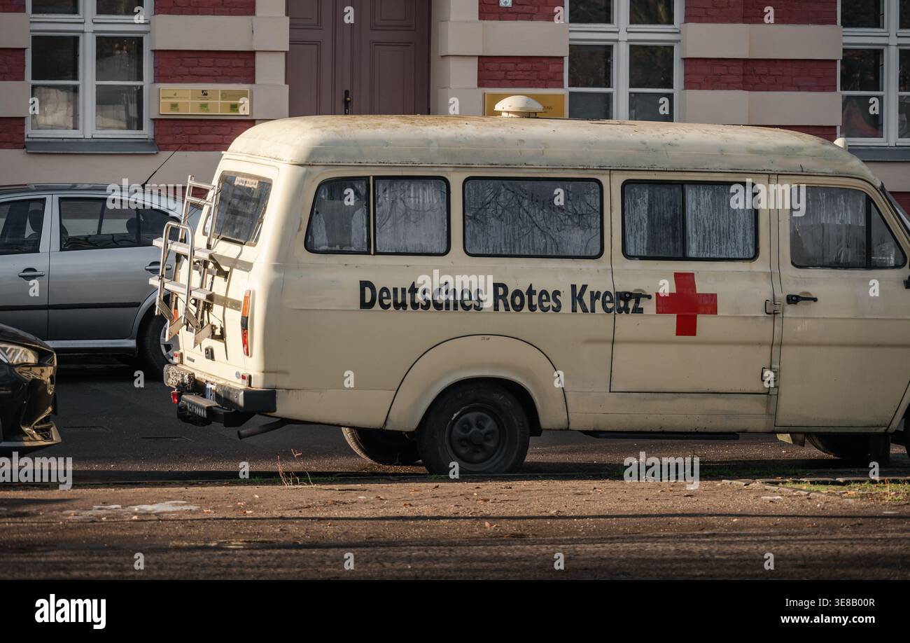 Vintage-Minibus mit deutschem Rotem Kreuz. Klassischer beigefarbener oder cremefarbener Ford Transit-Van mit deutschem Rotes Kreuz-Logo und rotem Kreuz-Logo auf einer Straße Stockfoto