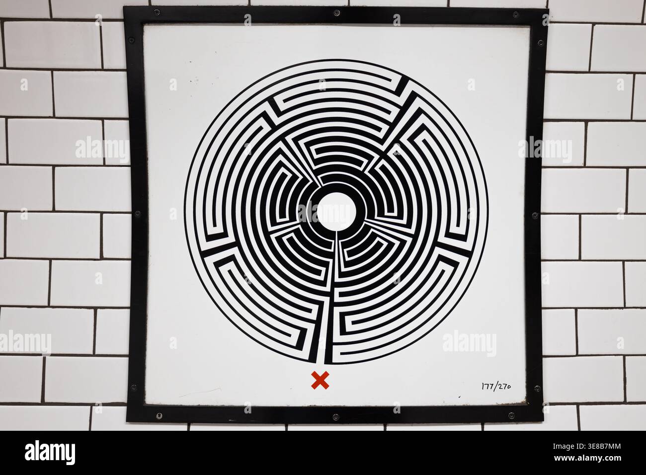 Gerahmtes schwarz-weißes OP-Art-Poster auf weißer U-Bahn-Wand Stockfoto