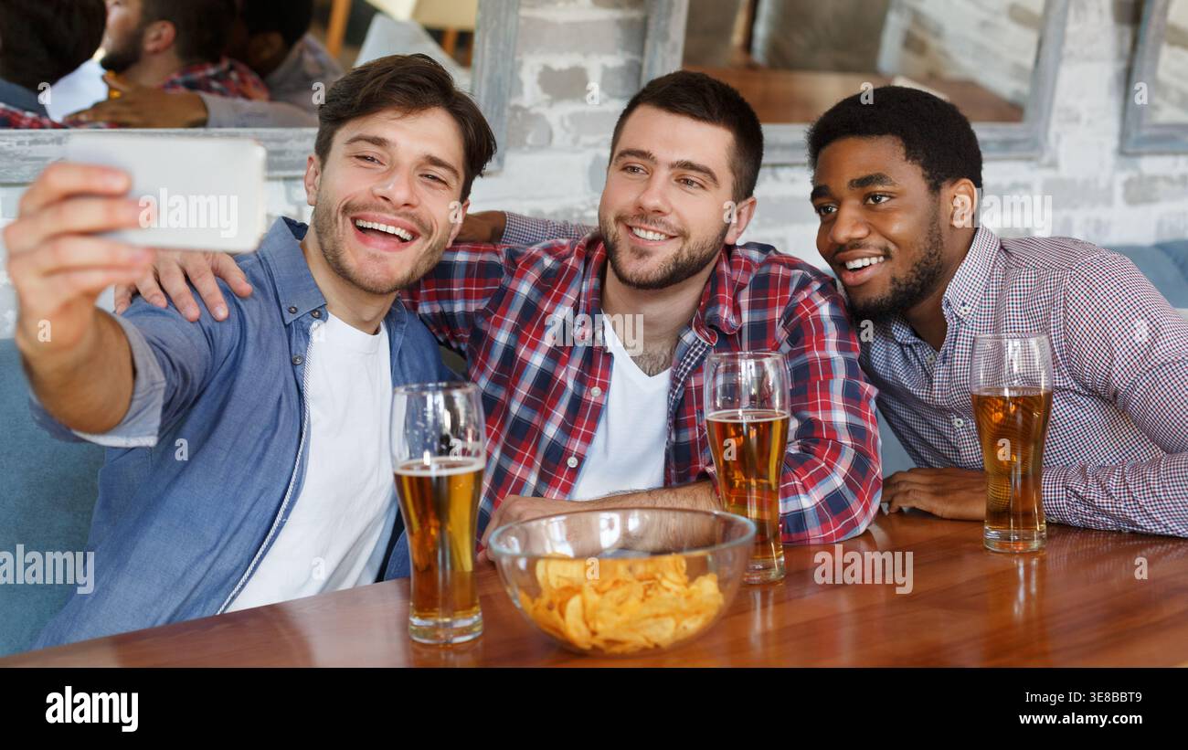 Selfie Zeit. Diverse Freunde im Pub und trinken Bier Ausruhen Stockfoto