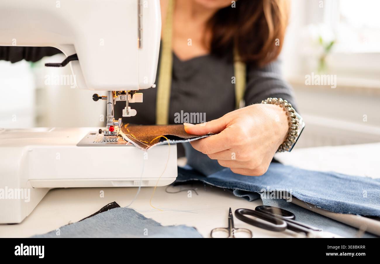Frau näht zu Hause mit Einer Nahaufnahme der Benutzung Einer Nähmaschine Stockfoto