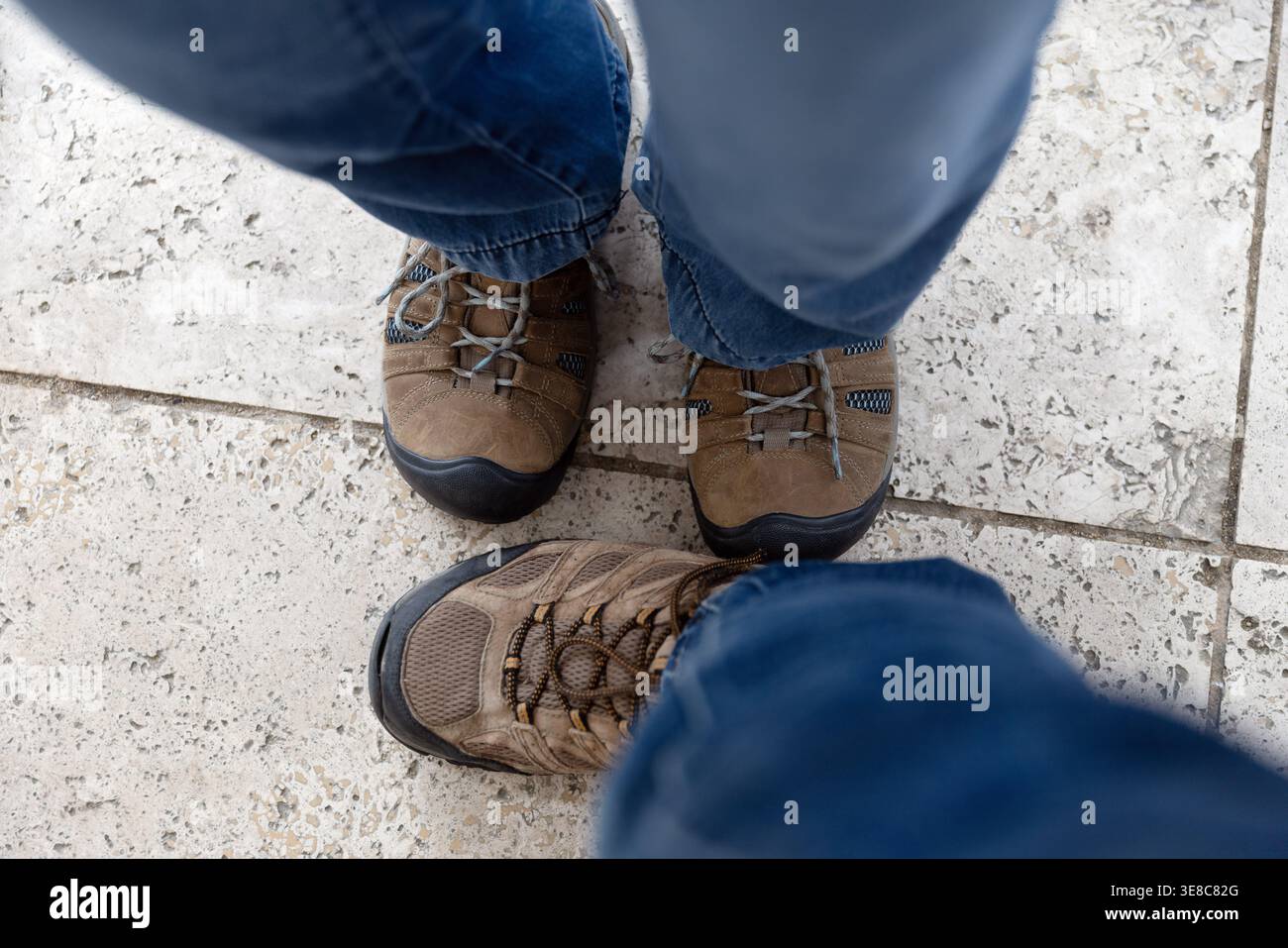 Zwei Paar Wanderschuhe auf gefliestem Boden, Blick von oben Stockfoto