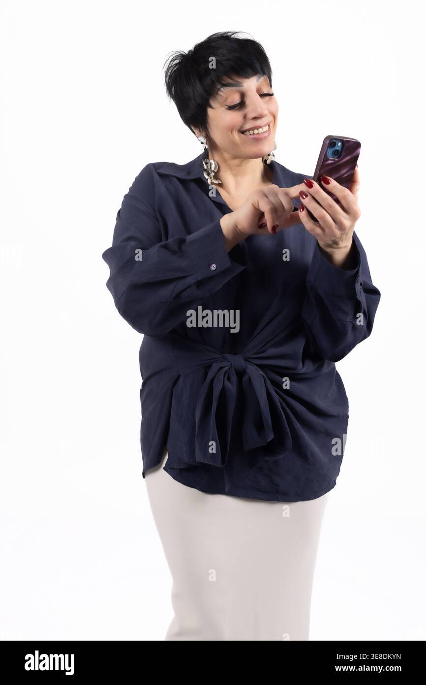 Frau, die auf ihren Telefonbildschirm auf weißem Hintergrund schaut Stockfoto