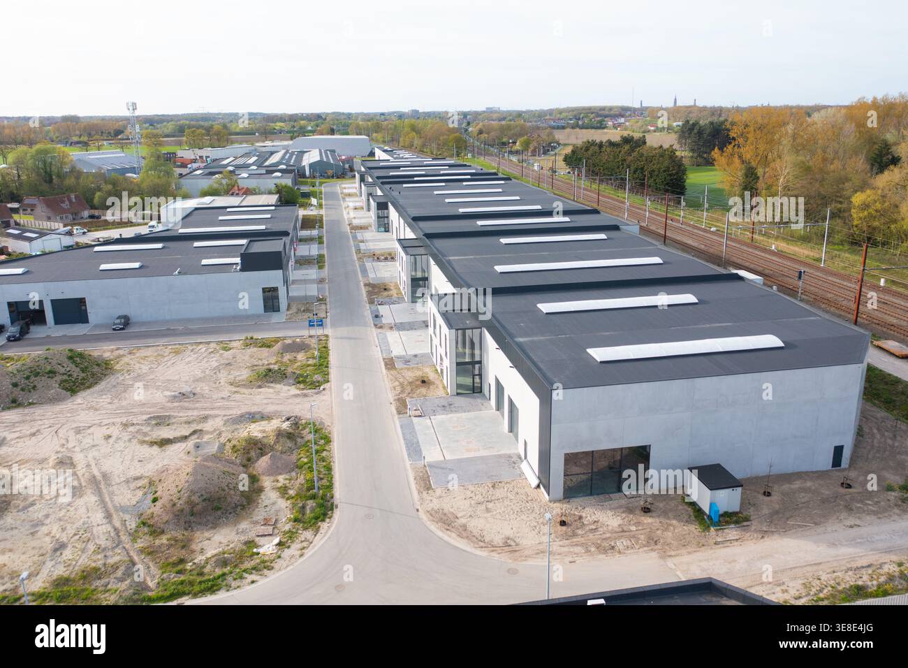 Aus der Vogelperspektive moderner Industriearchitektur mit klaren Linien und minimalistischem Design, gegenüber der natürlichen Landschaft, Oostkamp, Flandern, BE Stockfoto