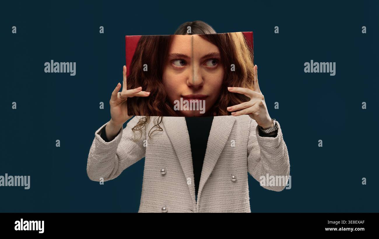 Junge Frau, die ein bedrucktes Gesichtsfeld hält, das sich an einem echten Studio-Porträt anpasst. Stockfoto