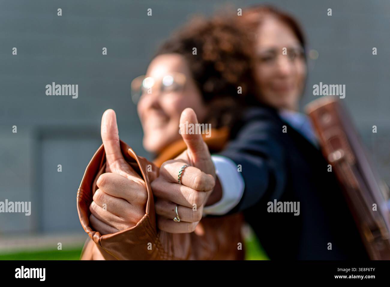Geschäftsfrauen zeigen Daumen hoch und arbeiten gemeinsam am Erfolg Stockfoto