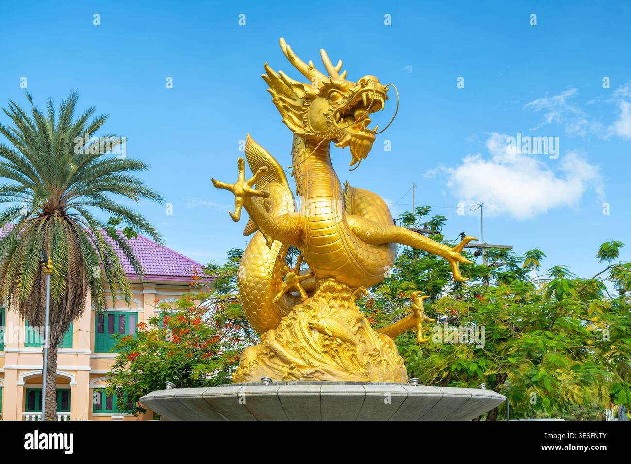 Brunnen der goldenen Drachen-Statue in Phuket, Thailand. Traditionelle asiatische mythische Kreaturen in urbaner Umgebung mit tropischen Pflanzen Stockfoto