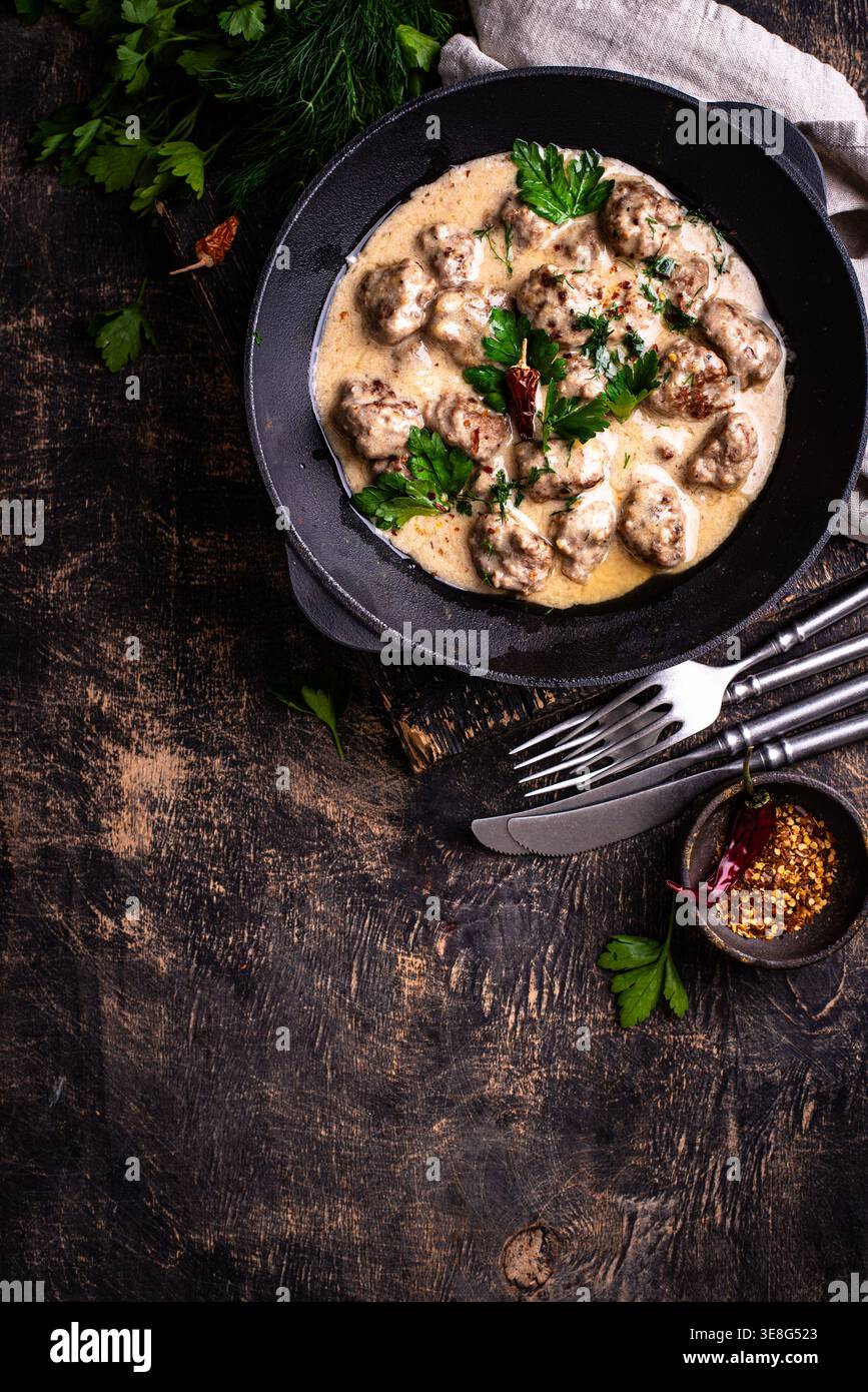 Fleischbällchen in Sauerrahmsauce in einer Pfanne Stockfoto