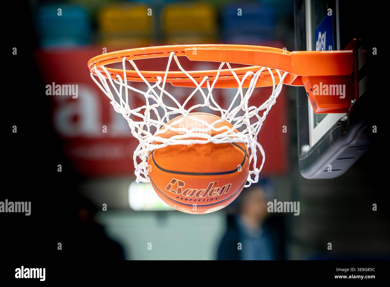 Basketball fällt während eines Spiels durch den Basketball, Nahaufnahme des Punktzeitpunkts, der Erfolg, Präzision und Leistung im Sport symbolisiert. Stockfoto