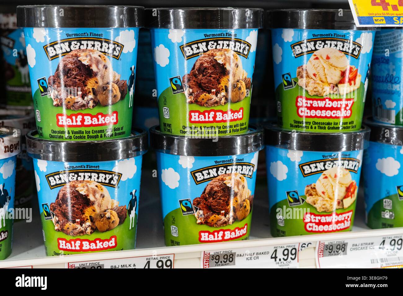 Ben & Jerrys halbgebackene Eisbecher-Behälter werden im Grocery Store Frozen Dessert Shelf im Retail Freezer Section ausgestellt Stockfoto