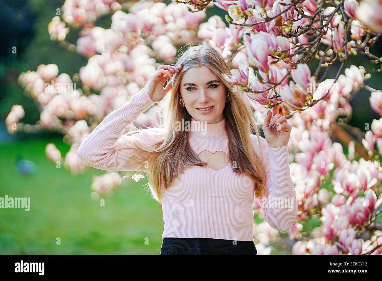 Weibliches Porträt mit Magnolienblüten, frühlingshafter Eleganz und romantischem natürlichem Hintergrund. Stockfoto
