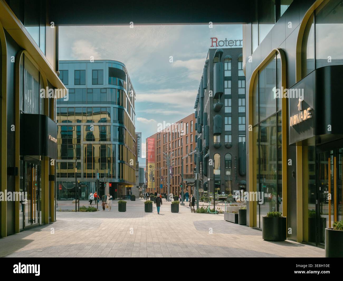 Fußgänger laufen durch das Rotermann Viertel, ein modernes gemischtes Viertel mit Glas- und Backsteinhäusern in Tallinn, Estland, im Frühling Stockfoto