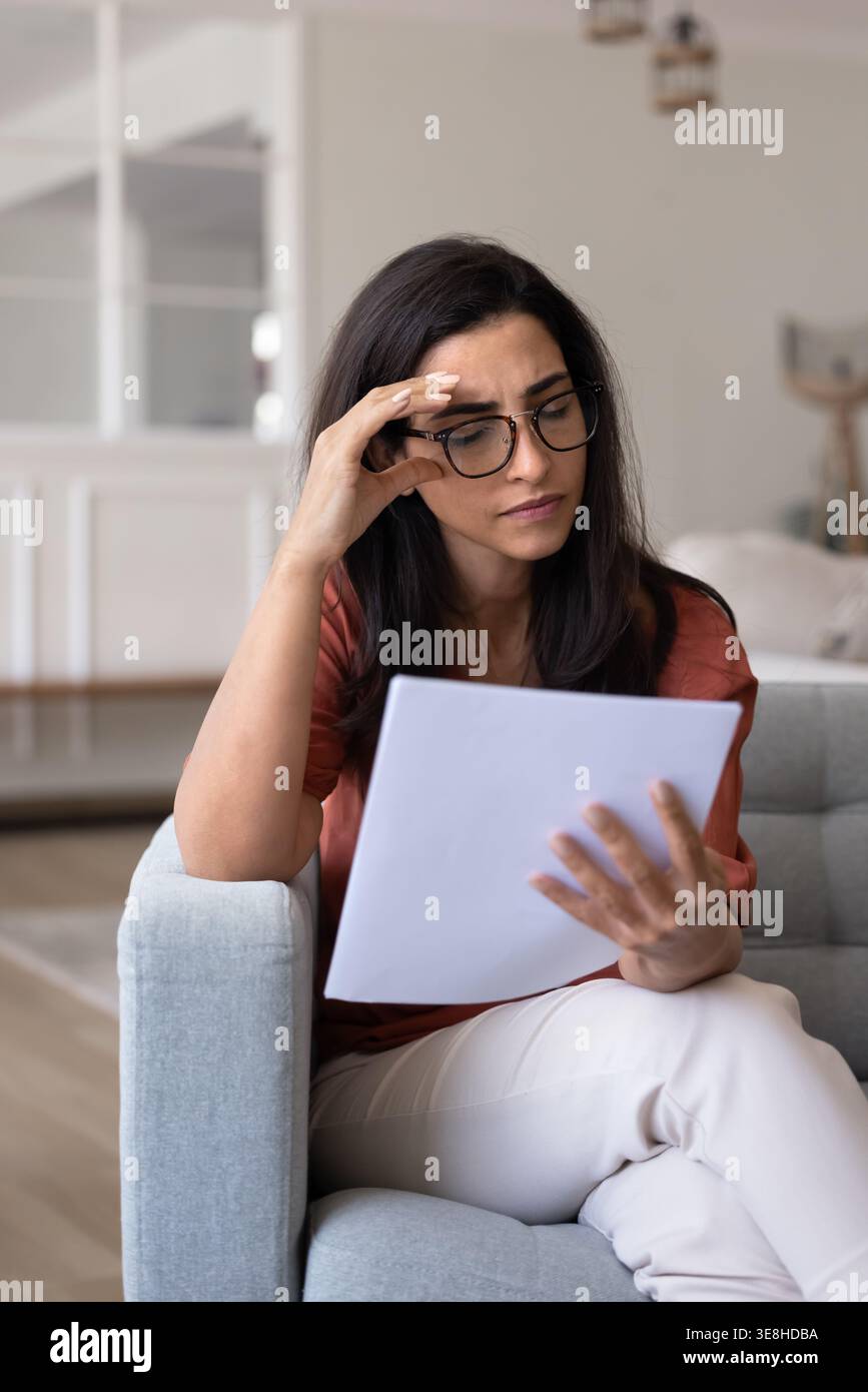 Besorgte Latina hat schreckliche Neuigkeiten in der Zeitung bekommen Stockfoto