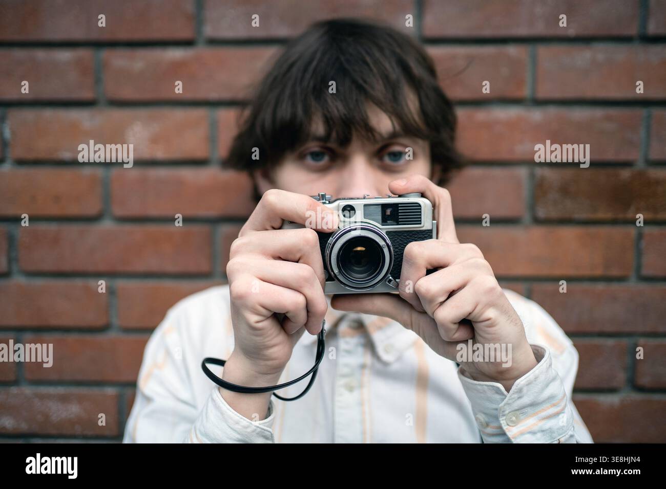 Analoge Fotografie junger Mann mit Vintage-Kamera, Retro-Lifestyle, Nostalgiekonzept, Jugendkreation. Stockfoto