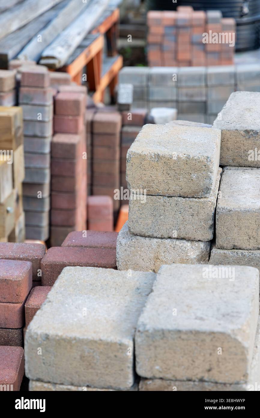 Pflastersteine und Ziegelsteine auf einer Baustelle, bereit für die Landschaftsgestaltung und den Bau Stockfoto