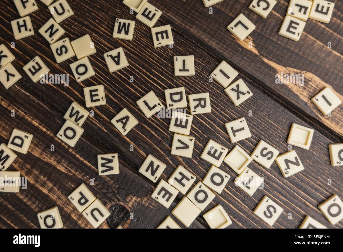 Lemberg Ukraine 02.26.26 Spieler versammeln sich am Nationalfeiertag um einen Holztisch. Die Buchstabensteine werden ausgebreitet, während sie sich auf ein lustiges Spiel vorbereiten. Stockfoto