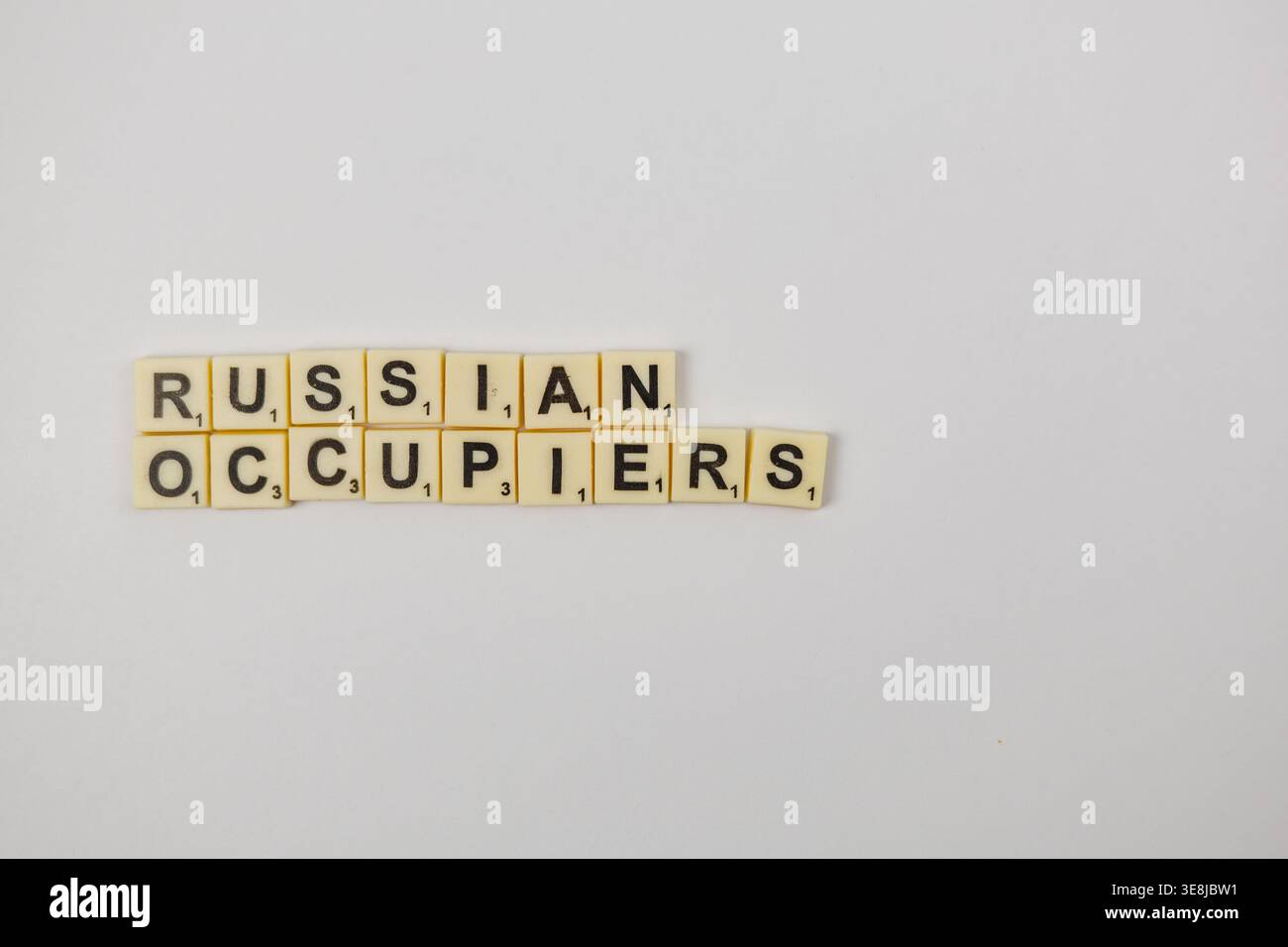Lemberg Ukraine 02.26.26 Spieler verwenden Scrabble-Steine, um Wörter auf einer glatten Oberfläche für den nationalen Scrabble-Tag zu erstellen. Die Buchstaben bilden die Wörter RUSSISCH und Stockfoto