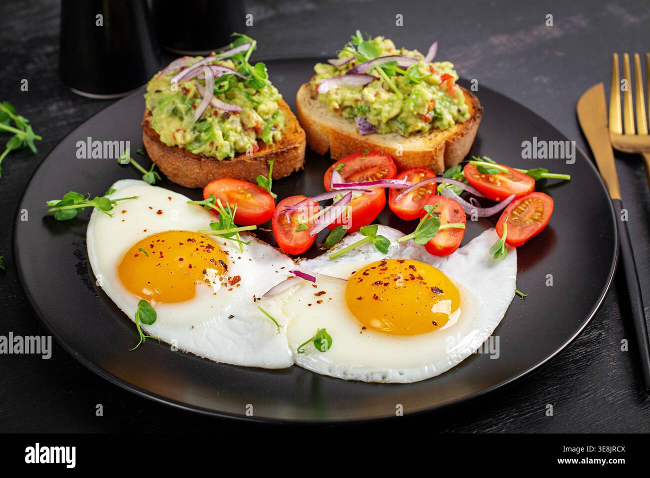 Proteinreicher Brunch mit sonnigen Eiern und Avocado-Toast Stockfoto