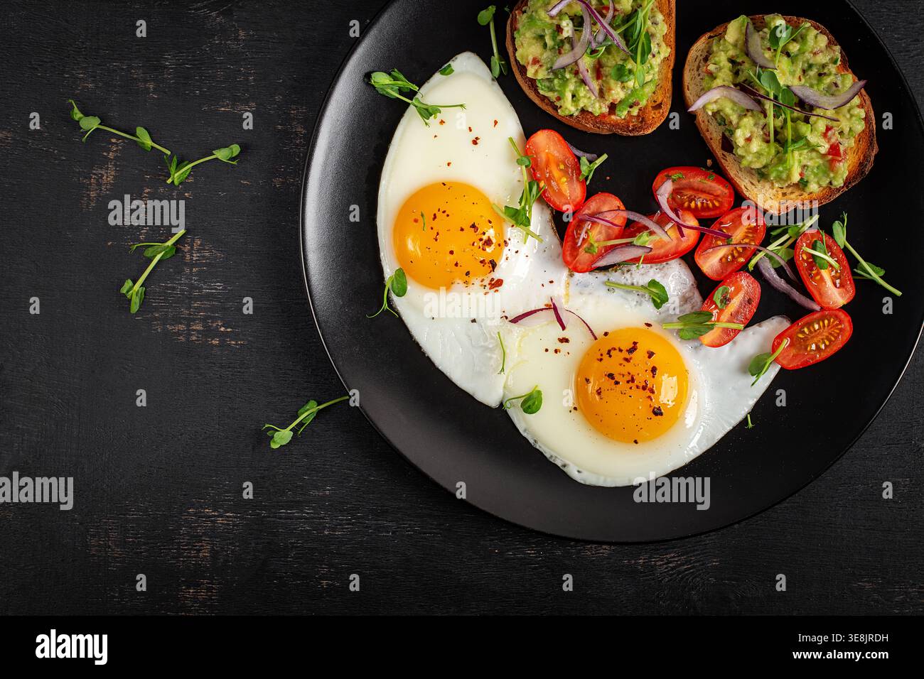 Proteinreicher Brunch mit sonnigen Eiern und Avocado-Toast, flacher Lay Stockfoto