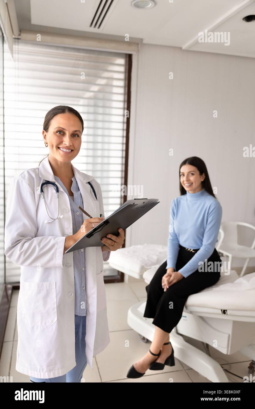 Porträt eines Arztes mit Klemmbrett, lächelnder Patient im Hintergrund Stockfoto