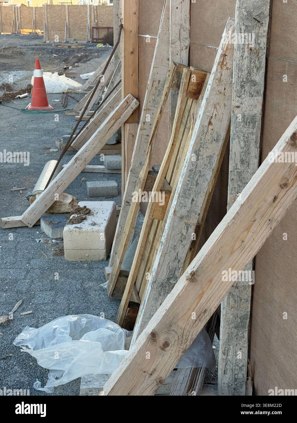 Baustelle mit verstreuten Holzbalken und -Materialien, mit abgenutzten Texturen und Schutt. Mobiles Foto Stockfoto