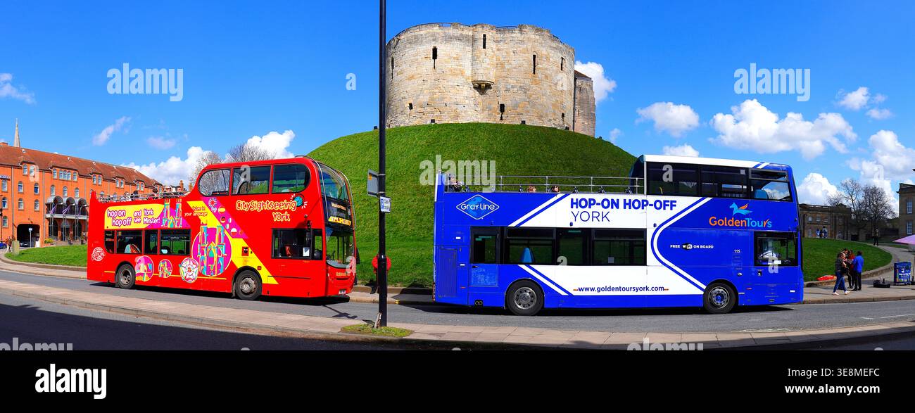 Offene Sightseeing-Busse vor Clifford's Tower in York City, North Yorkshire, Großbritannien Stockfoto