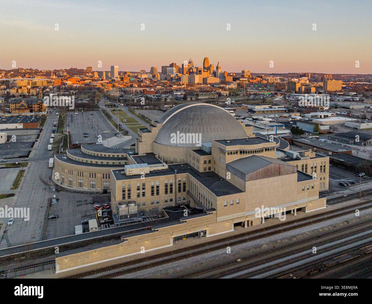 Aus der Vogelperspektive auf die beige Music Hall und die Union Terminal Station, die majestätisch vor den warmen Sonnenuntergängen der Skyline stehen, Cincinnati, Ohio, Uni Stockfoto