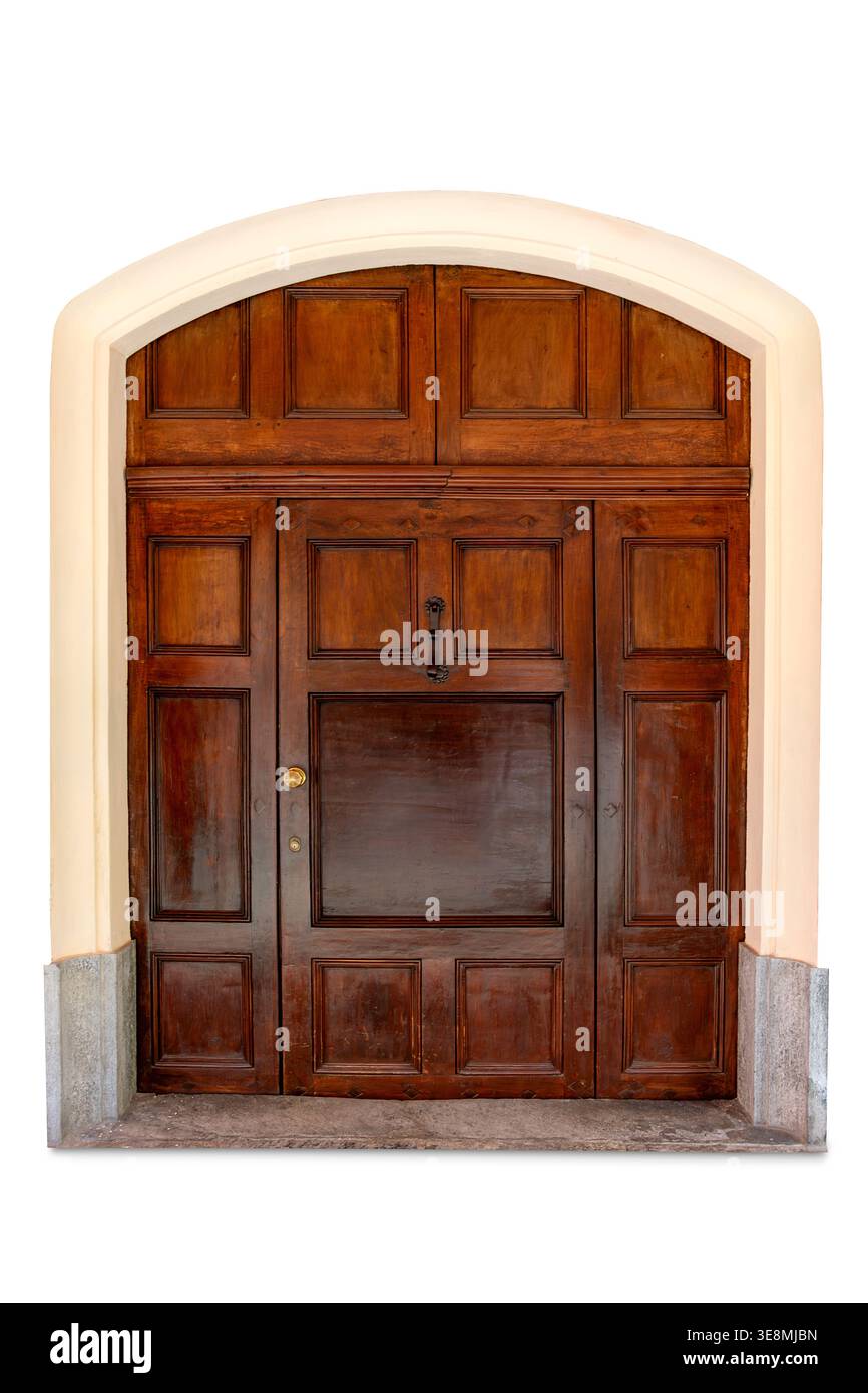 Elegante Tür aus Walnussholz mit rechteckigen Paneelen im klassischen Stil, eingerahmt von bogenförmigem Mauerwerk mit Steinfuß, isoliert auf weißem Hintergrund Stockfoto
