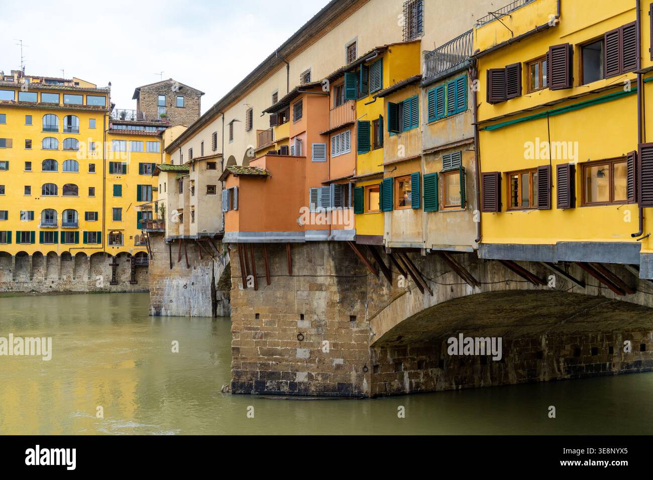 Berühmte Brücke Ponte Vecchio in Florenz, Italien, mit Geschäften und Häusern, die entlang des Flusses Arno gebaut wurden Stockfoto
