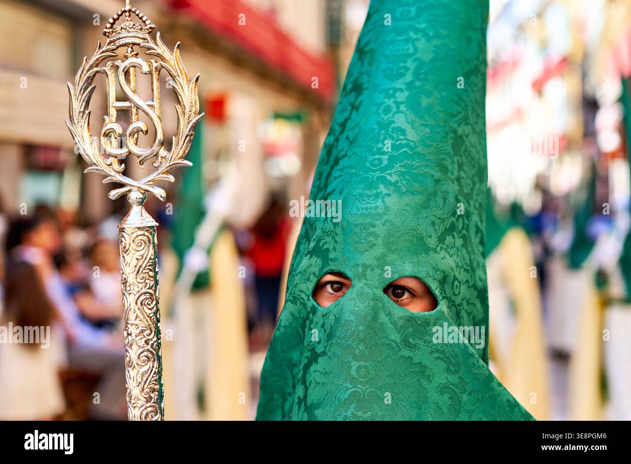 Die Menschen nehmen an den Osterprozessionen der Karwoche in Malaga teil. Die Teilnehmer tragen unverwechselbare Outfits und tragen religiöse Symbole durch die Straßen. Stockfoto