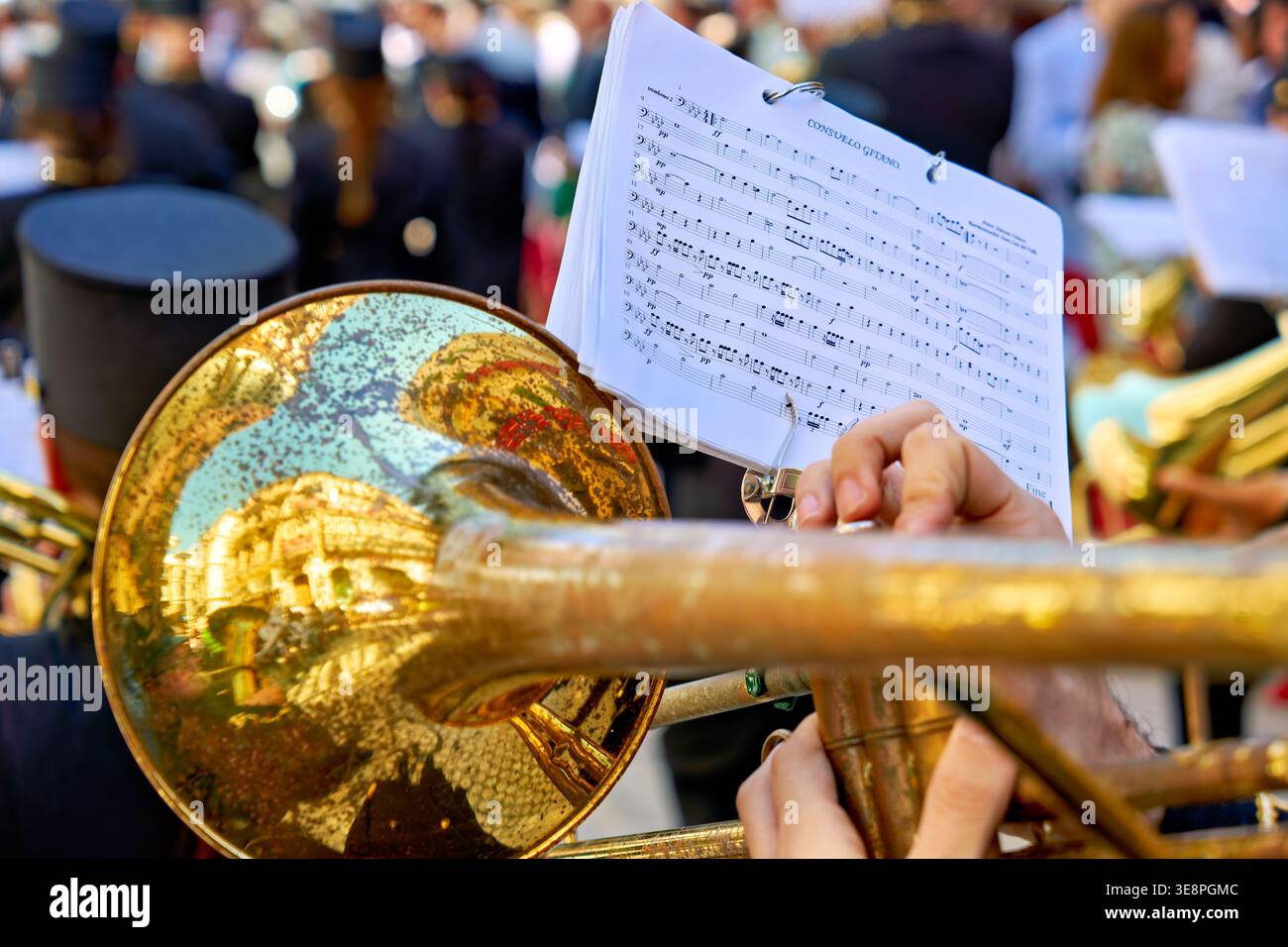 Musiker spielen Blechbläser, während zur Karwoche in Malaga, Andalusien, eine Prozession stattfindet. Die Szene ist lebhaft und festlich. Stockfoto