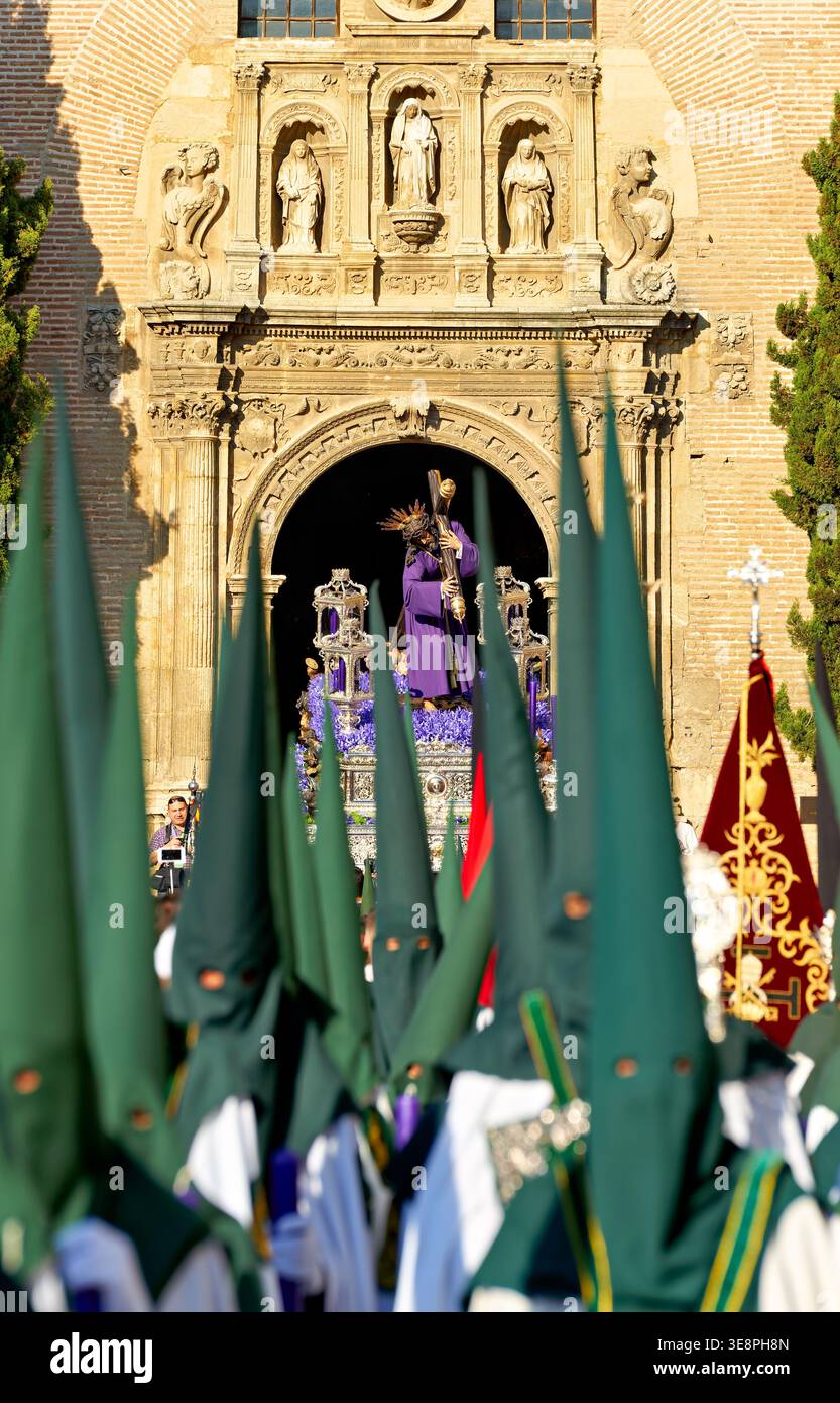 In Granada versammeln sich Menschenmassen, während die Prozessionen zur Karwoche stattfinden. Die Teilnehmer tragen traditionelle Bademäntel und religiöse Symbole. Stockfoto