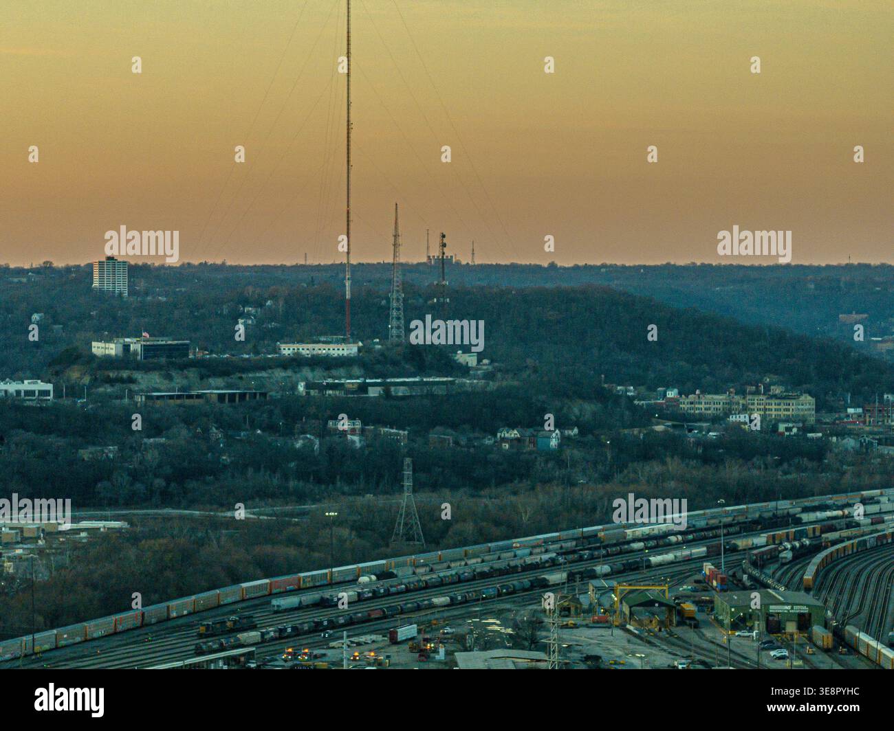 Cincinnati, USA - 27. Februar 2026: Aus der Vogelperspektive eines Bahnhofs, eingebettet in einen dichten Wald unter einem warmen, goldenen Himmel, mit hoher Kommunikation Stockfoto