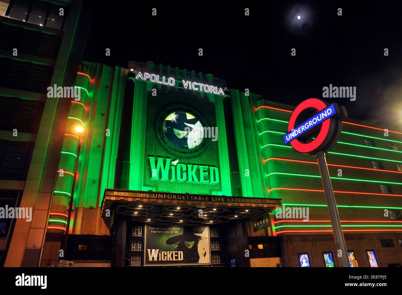Grüne und rote LED-Neonbeleuchtung mit Reklametafeln am Apollo Victoria Theatre bei Nacht, Heimstadion des Wicked the Musical. London, Großbritannien. Theater Musicals Stockfoto