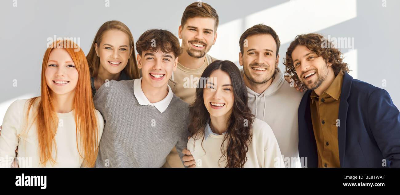Fröhliche, vielfältige Studentengruppe, die zusammen lächelt, Teamarbeit und Freundschaft im Studio Stockfoto