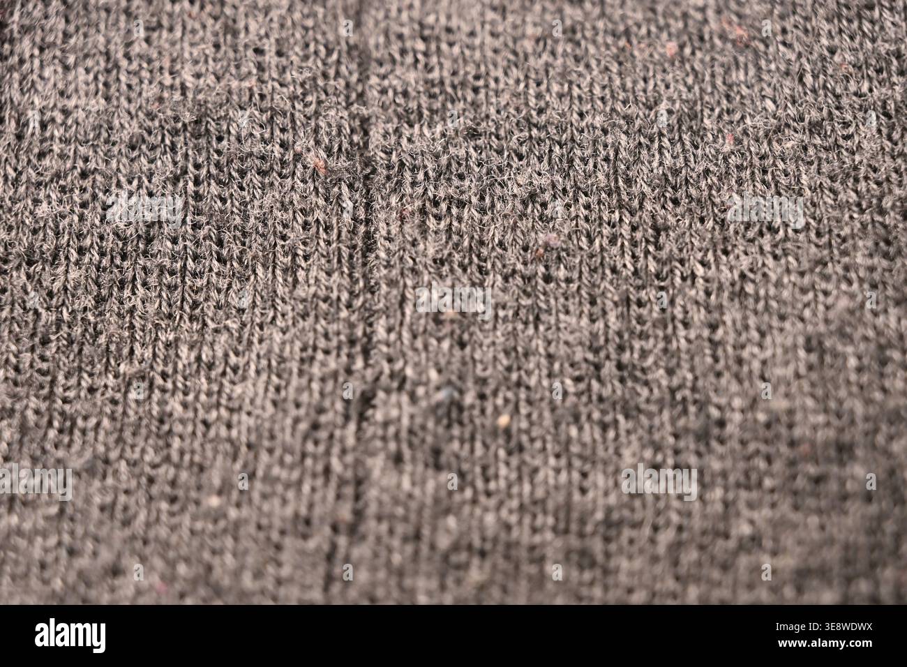 Graue Wollstoffstruktur – Nahaufnahme mit gezerknittertem Makro mit weichem, unscharfem Hintergrund Stockfoto
