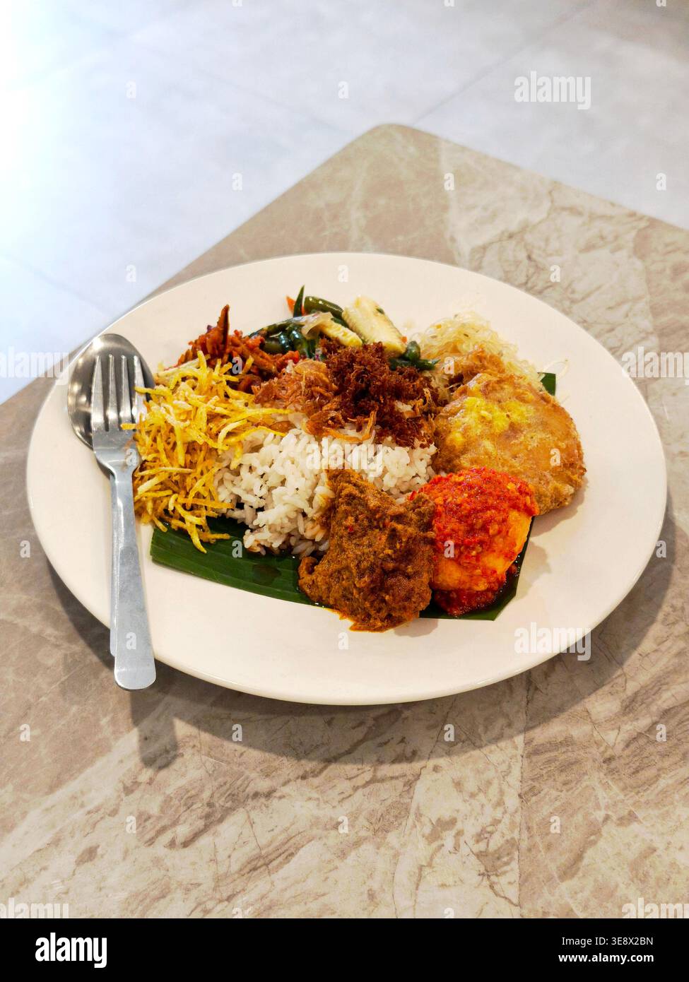 Nasi Lemak, eine malaiische Spezialität, die aus herzhaftem Reis besteht, der in Kokosmilch und Pandanblättern gekocht wird, ist in Malaysia, Indonesien und Brunei beliebt Stockfoto