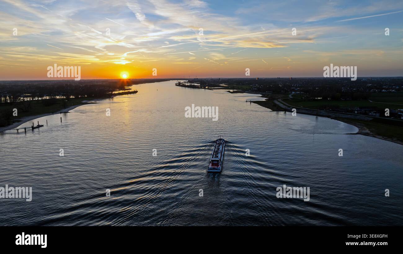 Frachtschiff auf einem Fluss bei Sonnenuntergang in Europa Stockfoto