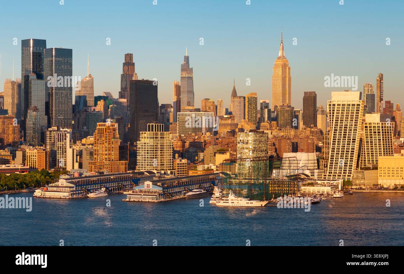 Panoramablick auf die Skyline von Manhattan bei Sonnenuntergang mit Wolkenkratzern in Midtown, Hudson River Uferpromenade und Chelsea Piers. New York City, USA Stockfoto