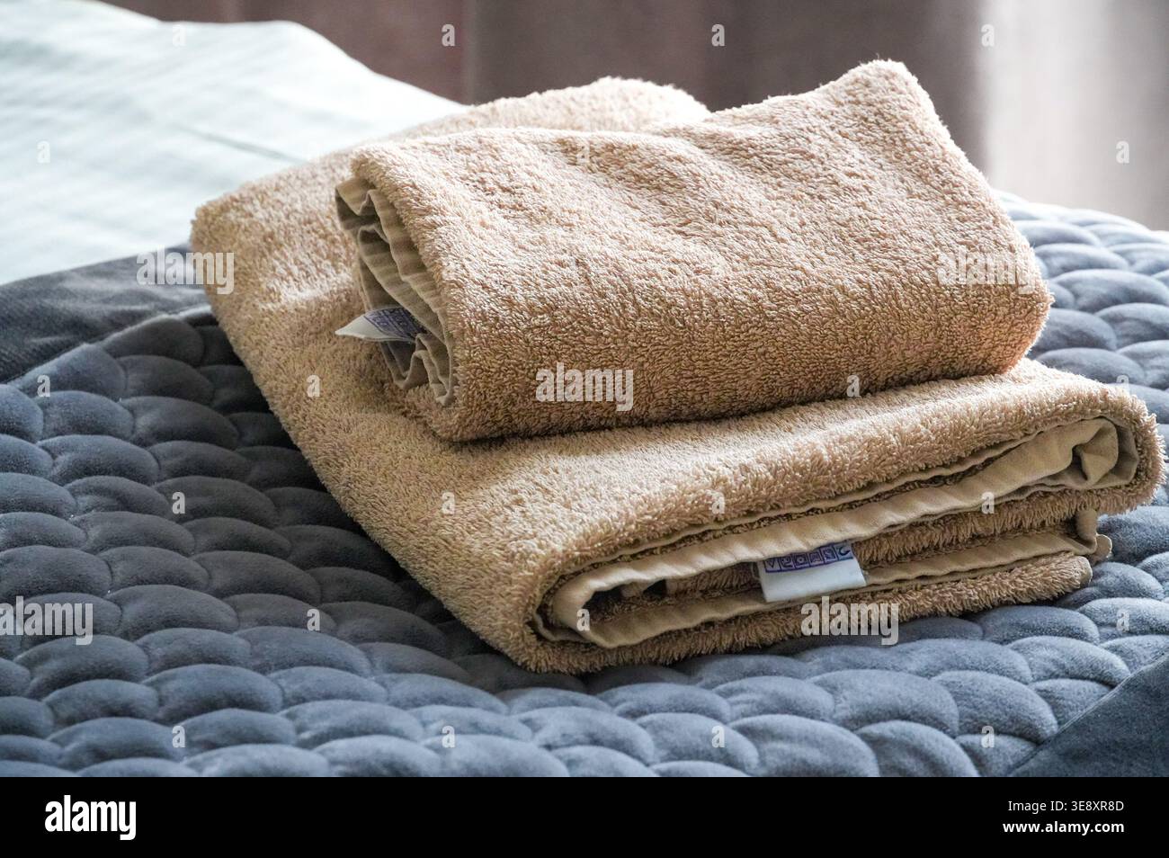 Nahaufnahme eines Stapels Handtücher auf einem Bett im Schlafzimmer Stockfoto