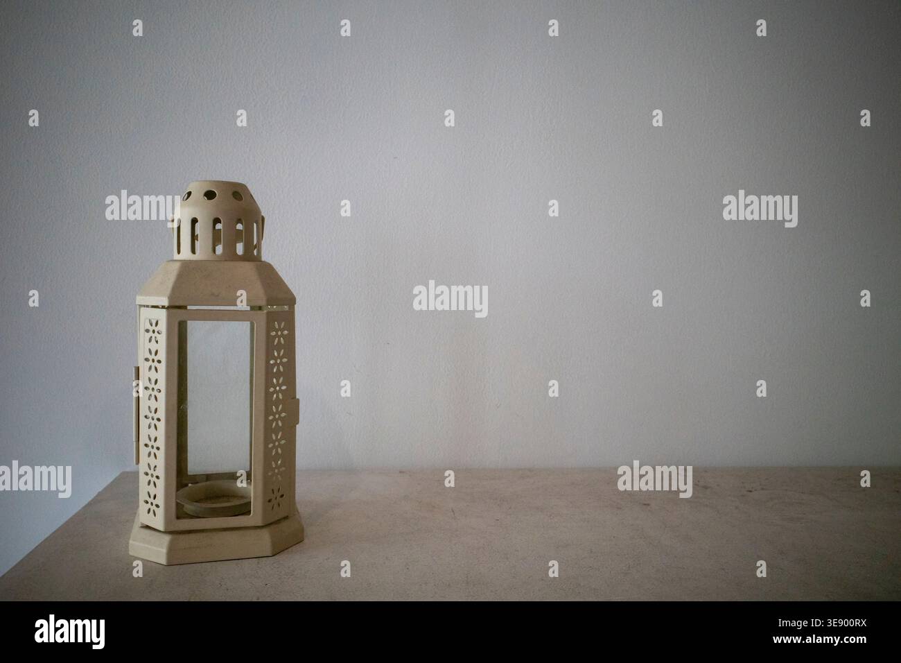Eine leere Ramadan-Laterne auf einem minimalistischen Tisch mit grauem Hintergrund. Stockfoto