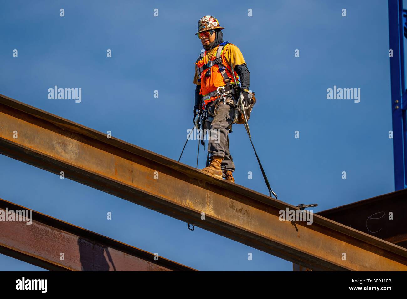 Eisenarbeiter, der während des Bauprojekts in der Innenstadt von Raleigh auf einem Stahlträger stand, veranschaulicht Facharbeiter und Stadtentwicklung. Stockfoto
