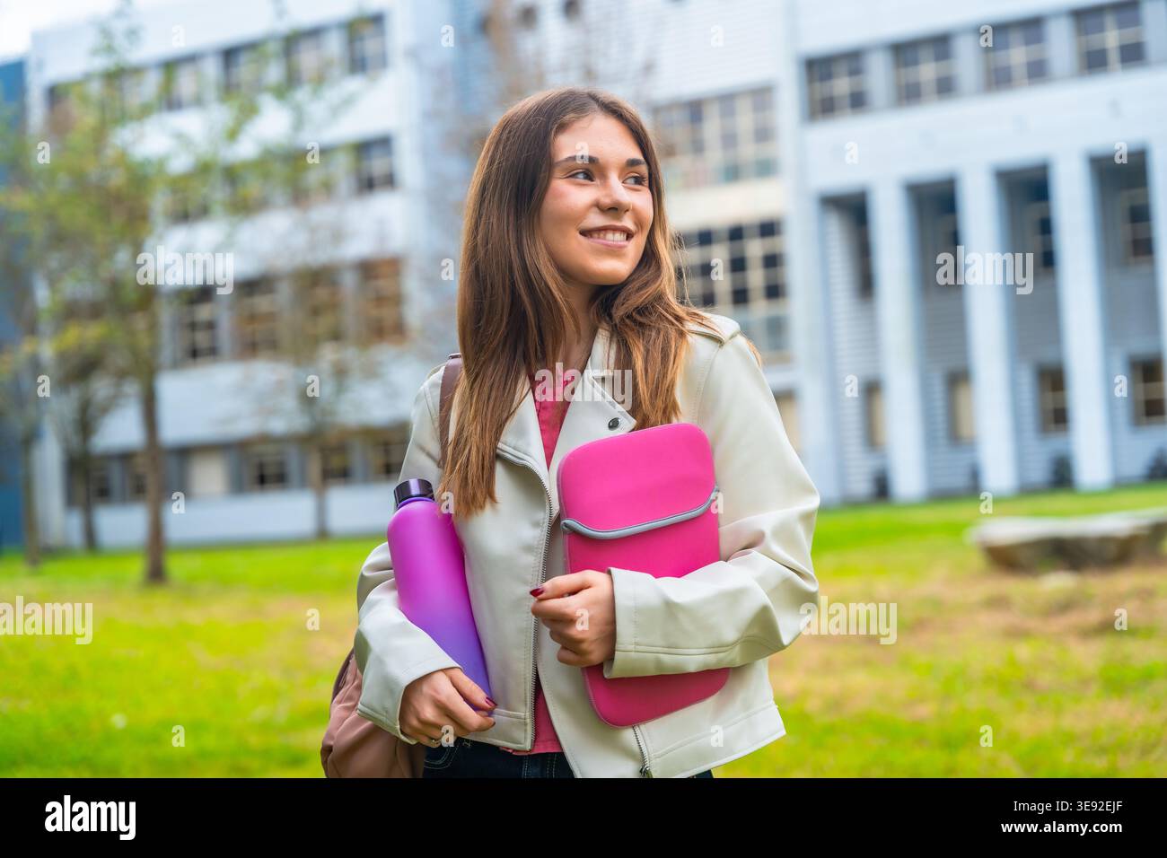 Junge Studentin lächelt auf dem Campus der Universität Stockfoto