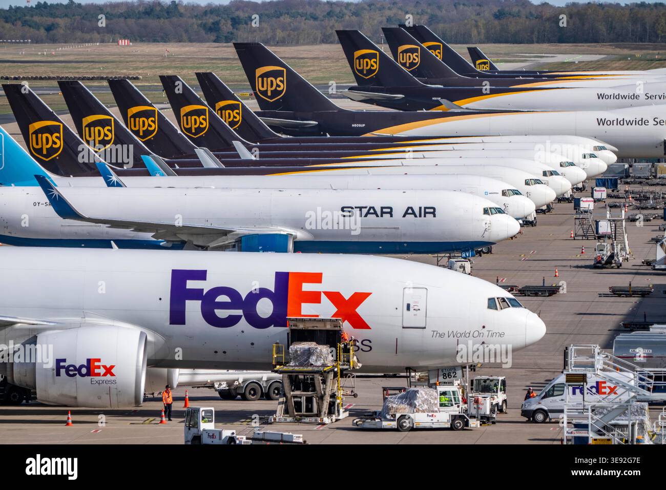 Ein Frachtflugzeug der FedEx Express Boeing 777-FS2 wird entladen, hinter dem Luftfrachtcontainer liegen, neben den Frachtflotten von Star Air, Maersk Stockfoto