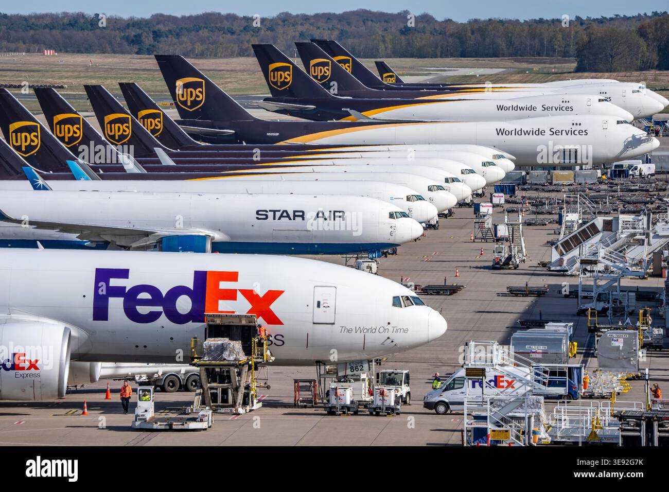 Ein Frachtflugzeug der FedEx Express Boeing 777-FS2 wird entladen, hinter dem Luftfrachtcontainer liegen, neben den Frachtflotten von Star Air, Maersk Stockfoto