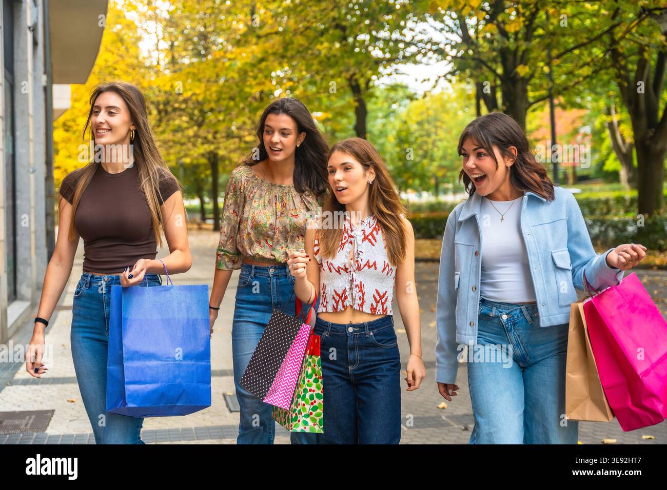 Glückliche Freunde, die gemeinsam einkaufen und das Herbstleben in der Stadt genießen Stockfoto