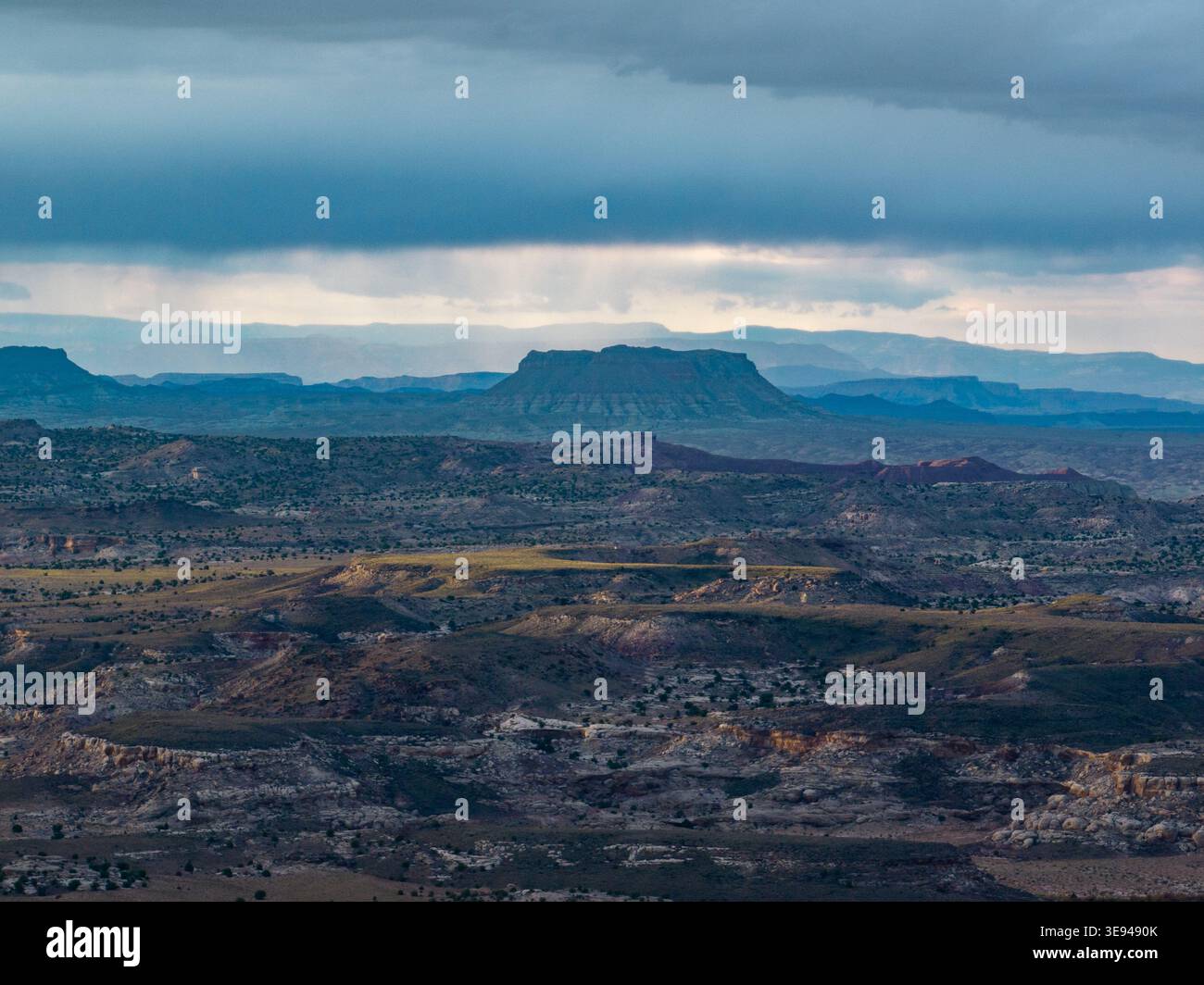 Aus der Vogelperspektive der bunten Bentonite Hills mit geschichteten Felsformationen unter einem dramatischen stürmischen Himmel mit Regenvorhängen in der Ferne Wayne Cou Stockfoto