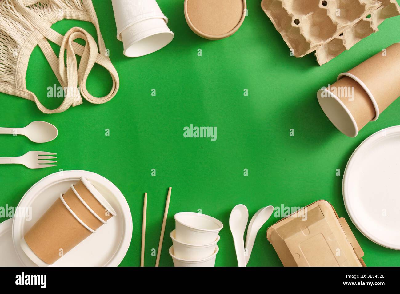Nachhaltige Verpackungen und Utensilien auf grünem Hintergrund Stockfoto