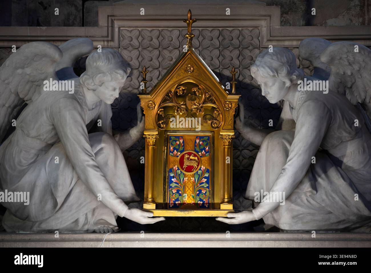 Marmordetail in der Kathedrale von Rouen: Zwei kniende Engel stützen ein vergoldetes neogotisches Reliquiar mit Agnus Dei und farbenfroher Blumenemaille. Stockfoto